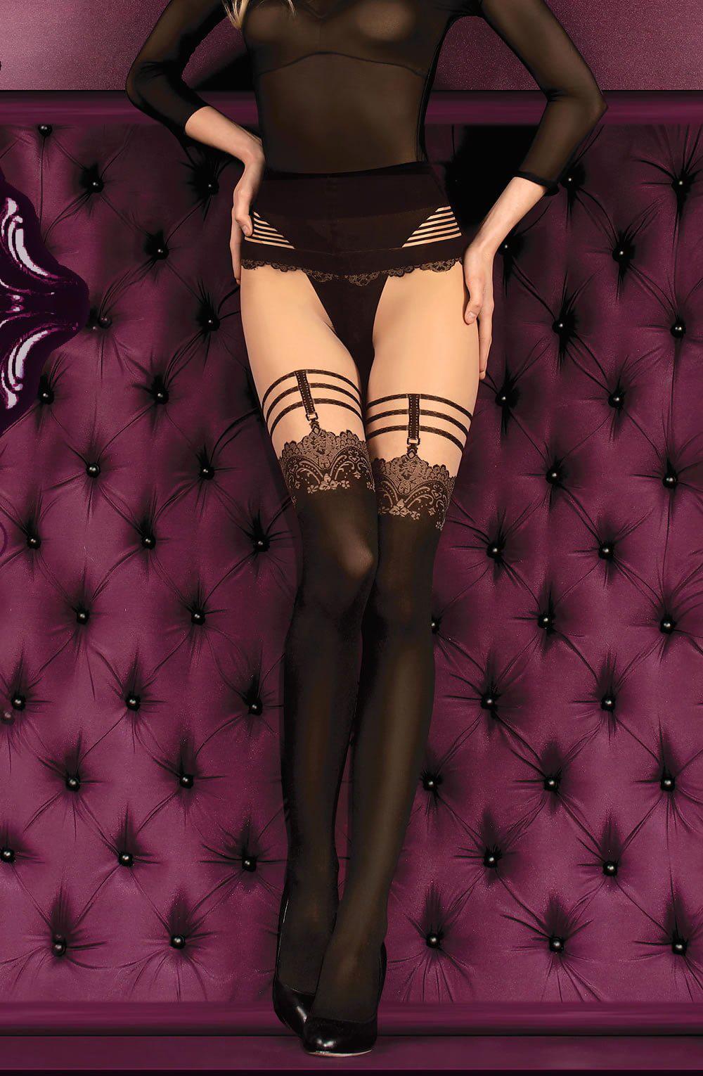 A person wearing a black sheer top, black lacy garter belt, and Ballerina 394 Tights Skin / Nero (Black) with a faux suspender design stands against a tufted, deep purple wall with a luxurious texture. Black stockings with lace tops and high heels complete the look. Only the torso and legs are visible.