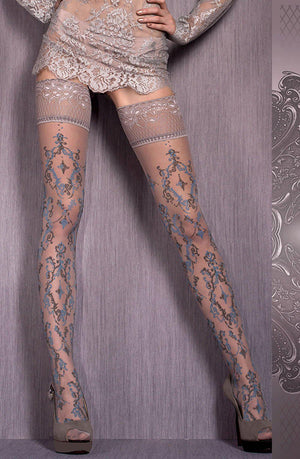 A person stands against a subtly decorated background wearing intricately patterned, semi-sheer Ballerina 416 Hold Ups Grey / Blue from the Ballerina collection. Their outfit includes a lace dress, and they are wearing high-heeled shoes.