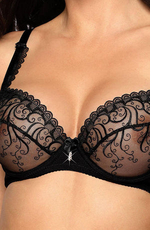 A close-up of a woman wearing the Roza Anuk Black Soft Cup from Roza, featuring intricate embroidery and sheer mesh cups. The black lace trim adds a touch of elegance, complementing the small embellishment at the center and adjustable straps. The image highlights the delicate design and detailing of this exquisite lingerie.