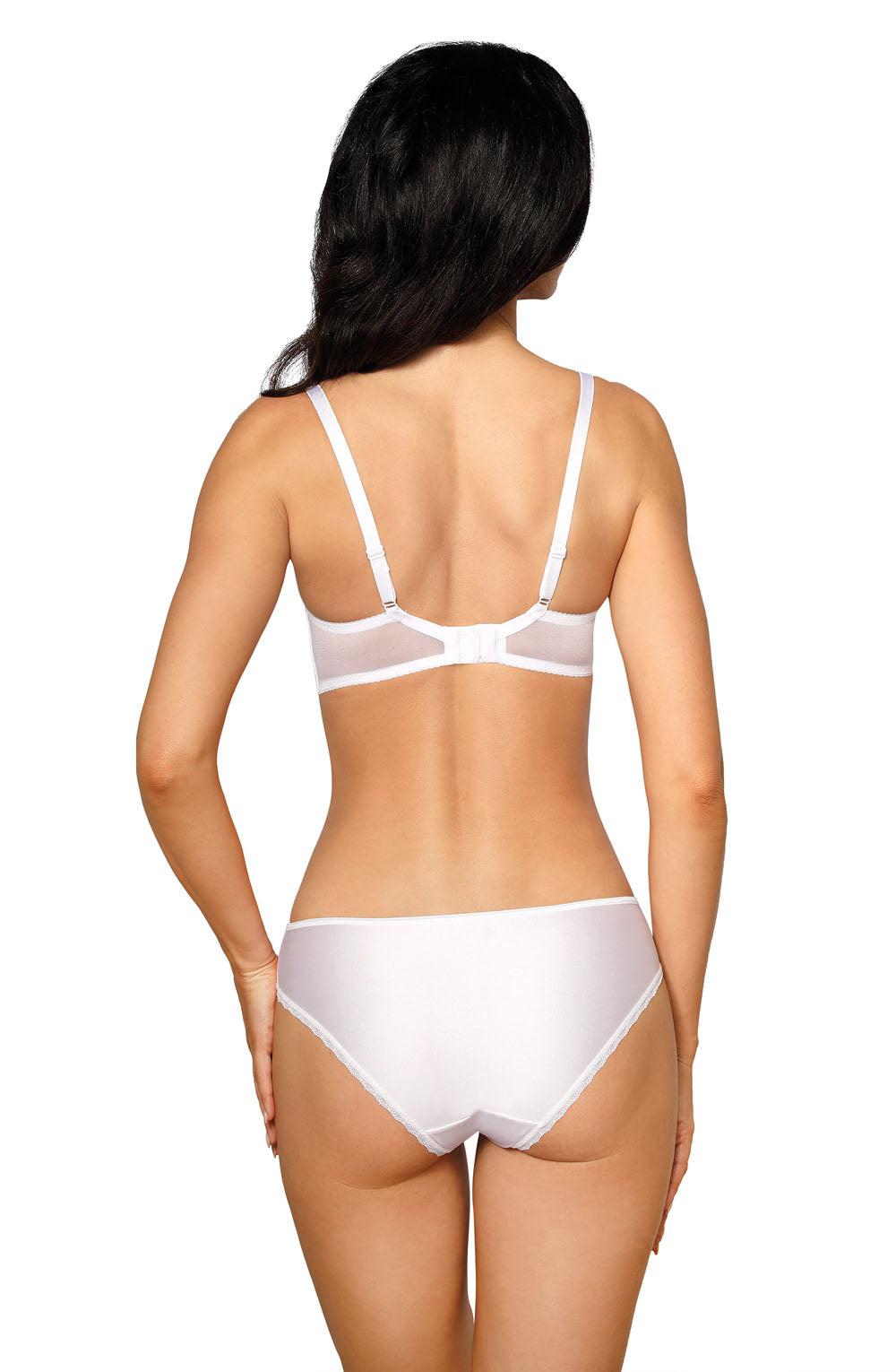 A woman with long dark hair showcases the Roza Anuk White Soft Cup bra and matching panties from the back. She stands with her arms relaxed at her sides, accentuating the adjustable shoulder straps and intricate embroidered detailing on the lingerie by Roza.