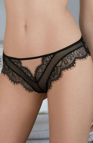 A close-up image shows a person wearing the Roza Idrisa Black Thong by Roza. The thong is made of sheer fabric featuring an intricate lace pattern and delicate scalloped edges. The image captures the waist, hips, and upper thighs of the person.
