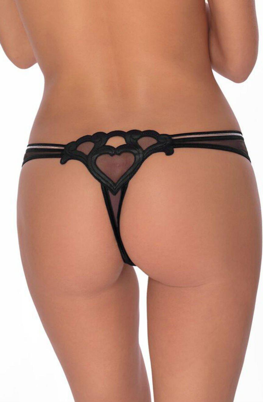 A person is seen from behind, wearing the Roza Lica Thong Black by Roza, which features delicate straps and intricate embroidery with a heart-themed design. The lingerie includes sheer fabric and heart-shaped cutouts, beautifully accentuating the piece against a plain white background.