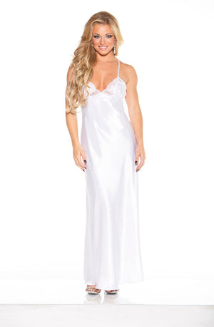 A woman with long, wavy blonde hair is wearing the Shirley Of Hollywood 20300 White Long Gown from Shirley of Hollywood. The elegant satin gown features lace-trimmed cups and intricate lace details on the bodice. Standing against a plain white background, she smiles and poses with one hand on her hip, complemented by her high-heeled shoes.