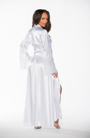 A woman wearing the Shirley of Hollywood 20559 Long Robe White, a floor-length charmeuse lace gown with long sleeves, poses against a white background. She looks over her shoulder with her right hand resting on her hip and her left leg exposed through a thigh-high slit in the gown, exuding Hollywood glamour.