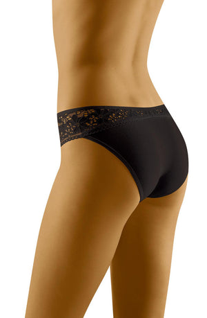 A person stands with their back to the camera, showcasing Wolbar Eco-Tu Black Briefs, featuring an intricate lace waistband.