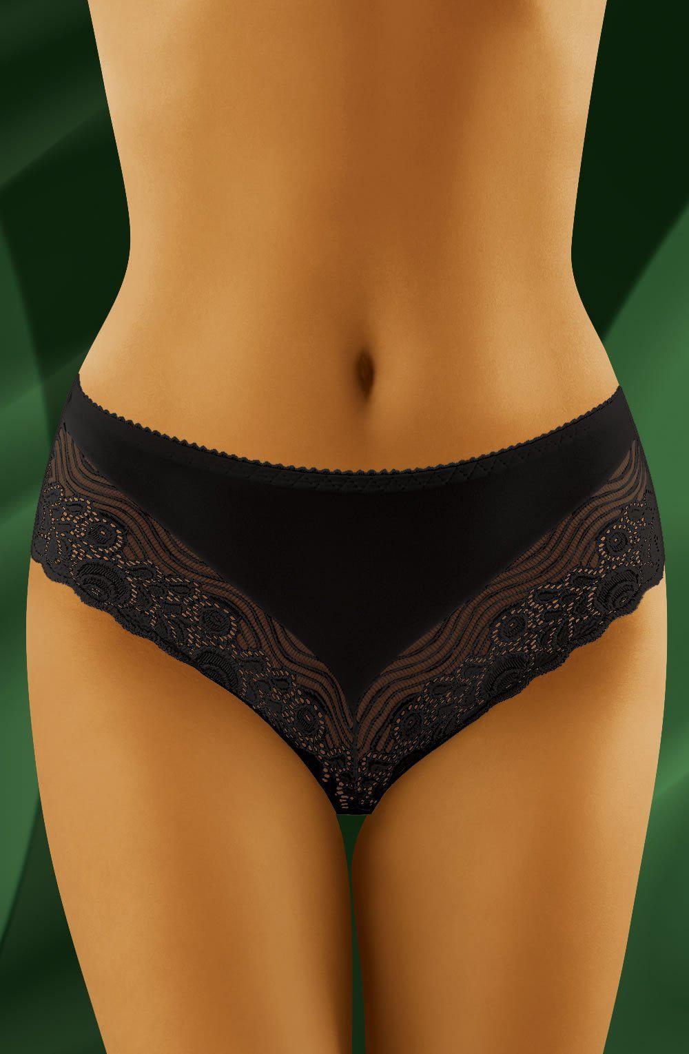 A close-up image of a woman wearing Wolbar Gaja II Black Briefs. The luxury lingerie from Wolbar features intricate lace detailing around the hips and smooth fabric in the front, creating a stylish and elegant look. The background showcases a gradient of dark green shades.